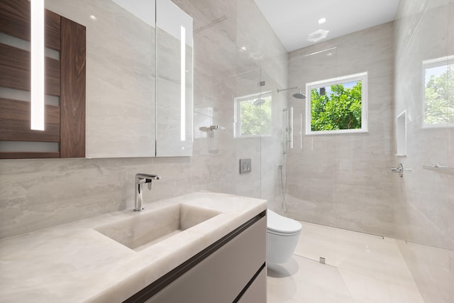 bathroom featuring toilet, a shower with door, vanity, tile walls, and tile floors