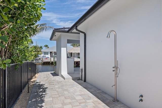 entrance to property with a water view and a patio area