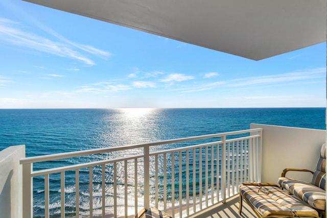 balcony featuring a water view and a beach view