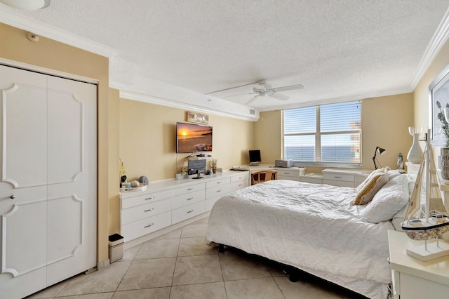 tiled bedroom with a closet, ceiling fan, crown molding, and a textured ceiling