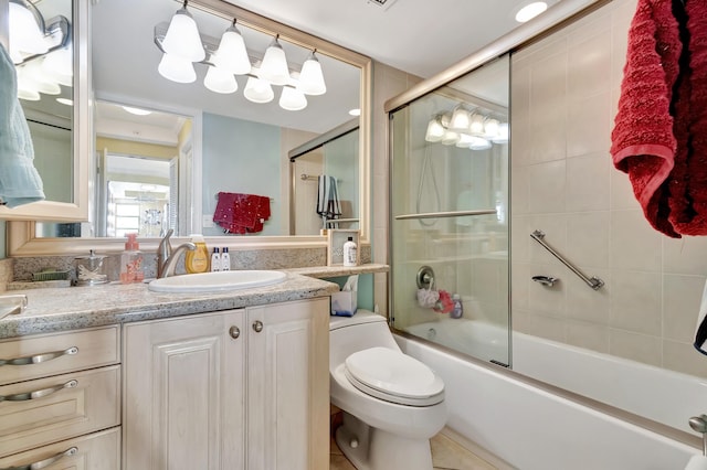 full bathroom with tile patterned floors, vanity, toilet, and shower / bath combination with glass door