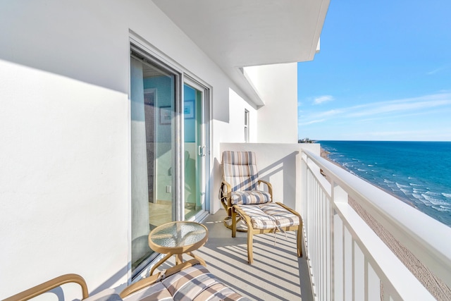 balcony featuring a water view and a beach view