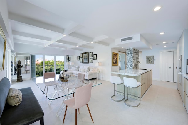 living room featuring beam ceiling, coffered ceiling, sink, and light tile floors