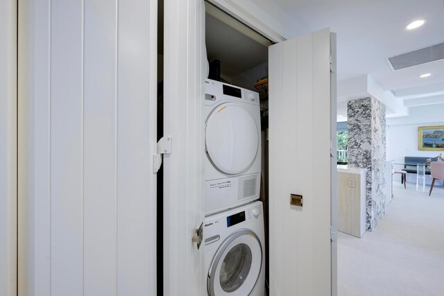 washroom featuring stacked washer and clothes dryer