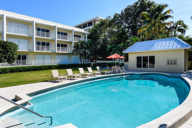 view of pool with a lawn