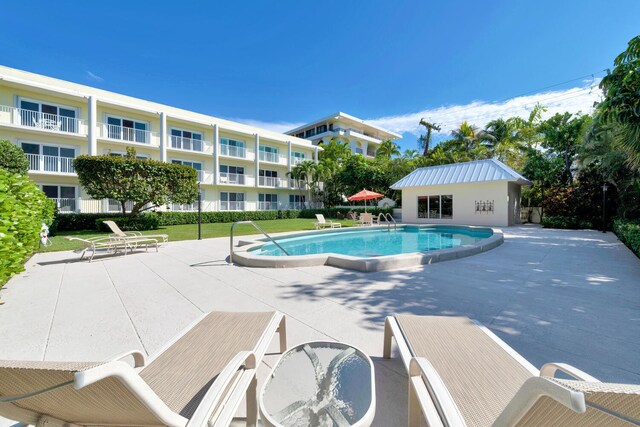 view of swimming pool with a lawn and a patio area