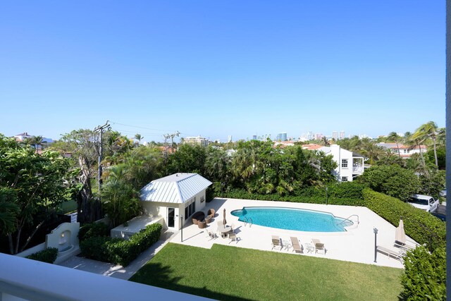 view of pool with a lawn and a patio area