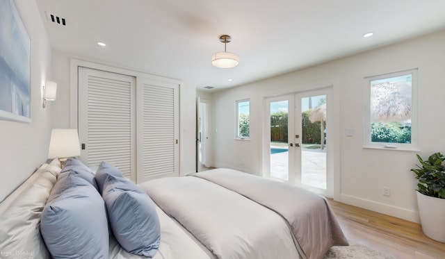 bedroom featuring light hardwood / wood-style floors, access to exterior, french doors, and a closet