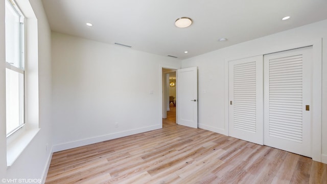 unfurnished bedroom featuring light wood-type flooring and a closet