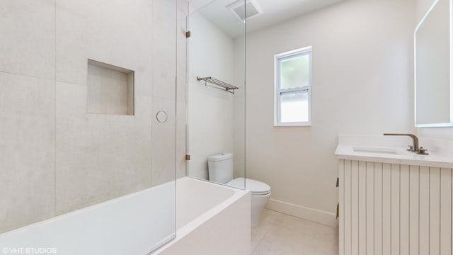 bathroom featuring tile patterned floors, a bathing tub, vanity, and toilet