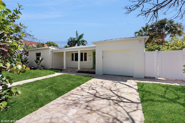 ranch-style house featuring a front yard, a garage, and covered porch