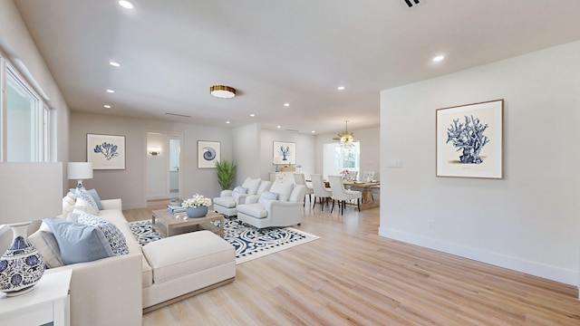 living room featuring a notable chandelier and light wood-type flooring