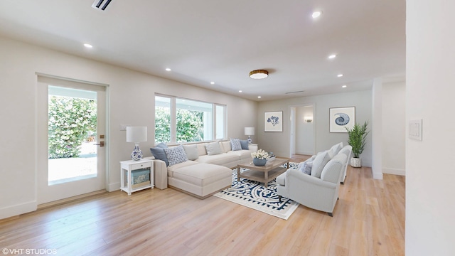 living room featuring light wood-type flooring and a healthy amount of sunlight