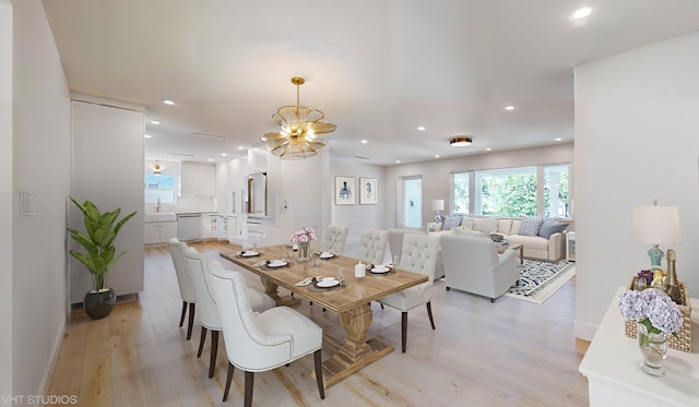 dining room featuring an inviting chandelier, light hardwood / wood-style flooring, and sink