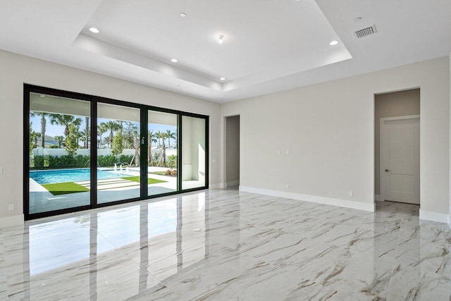 spare room with a tray ceiling