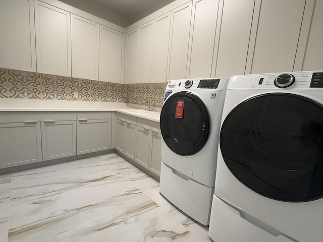 laundry room featuring cabinets, sink, and independent washer and dryer