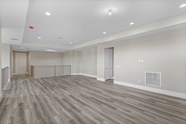 interior space featuring a raised ceiling and light wood-type flooring