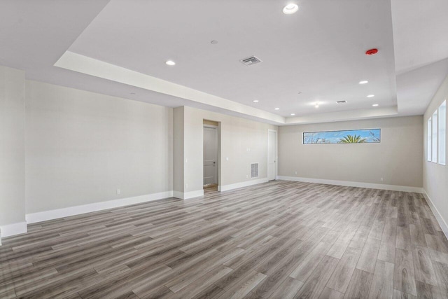 interior space with hardwood / wood-style flooring and a tray ceiling