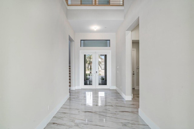 hallway with a towering ceiling and french doors