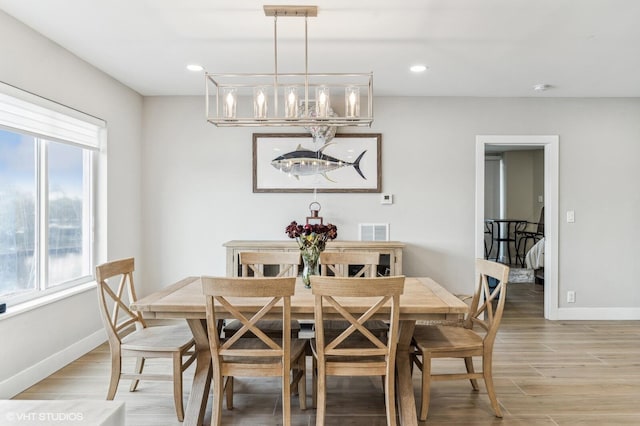 dining area with a chandelier and light hardwood / wood-style flooring