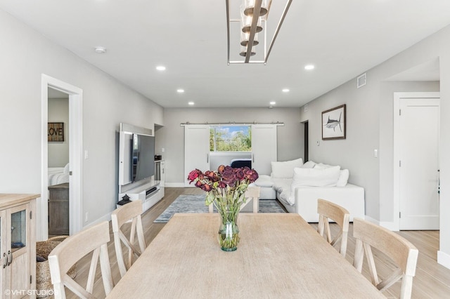 dining room featuring a notable chandelier and light wood-type flooring