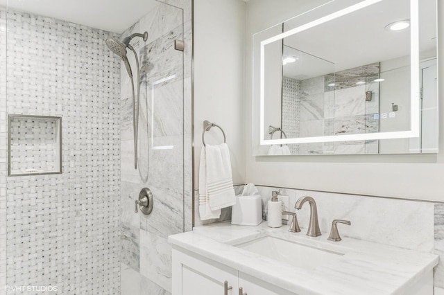 bathroom featuring a tile shower and vanity with extensive cabinet space