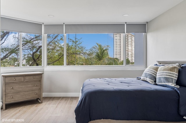 bedroom with multiple windows and light wood-type flooring