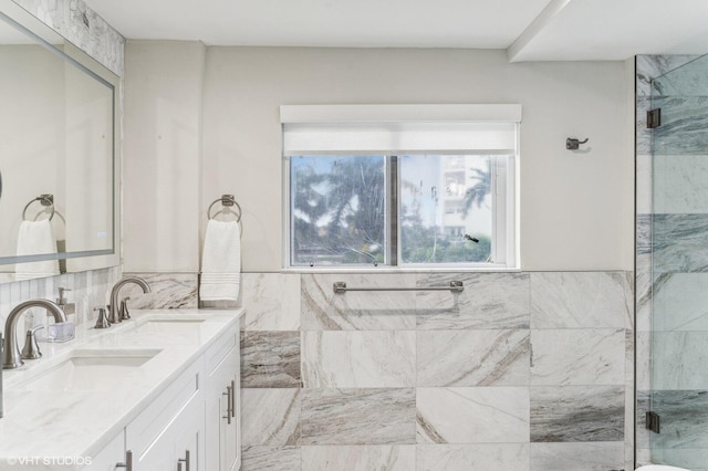 bathroom featuring double sink vanity and a shower with door