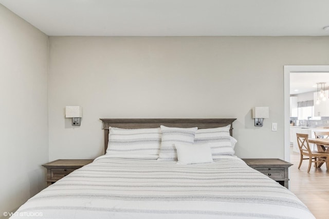 bedroom featuring a notable chandelier and light wood-type flooring