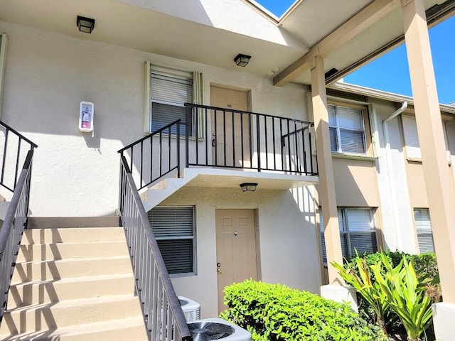 doorway to property with a balcony and central air condition unit