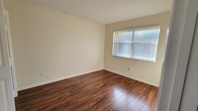 unfurnished room with a textured ceiling and hardwood / wood-style flooring