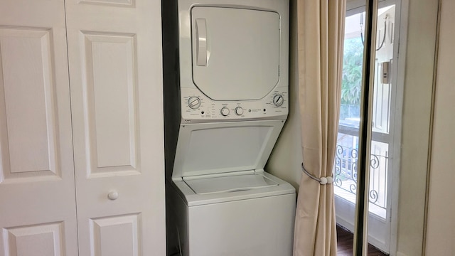 laundry room featuring stacked washer and dryer and hardwood / wood-style floors