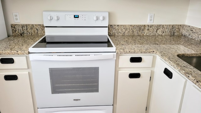 kitchen featuring white cabinetry, white range with electric stovetop, and light stone countertops