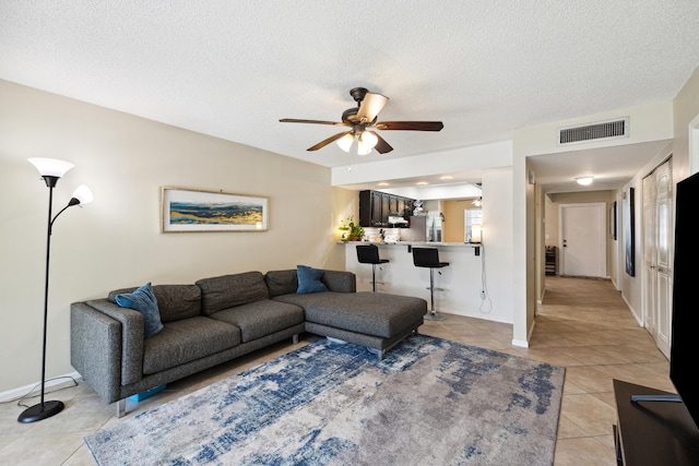 tiled living room featuring a textured ceiling and ceiling fan