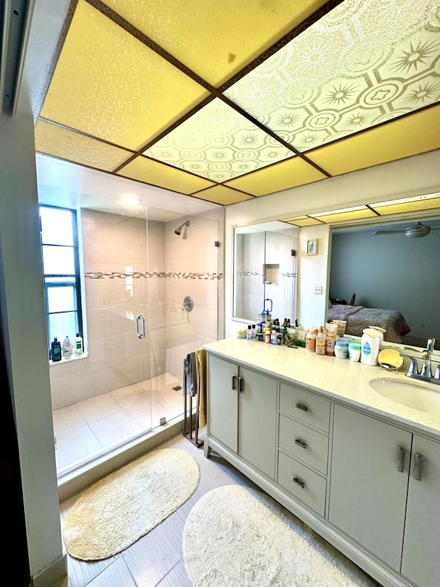 bathroom featuring a shower with door and vanity