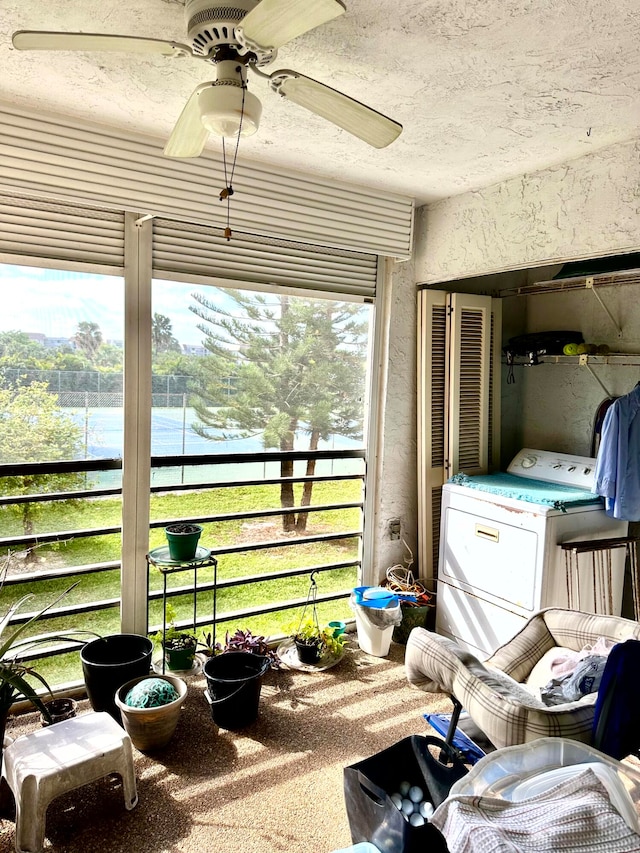 sunroom with ceiling fan, a water view, and washer / clothes dryer