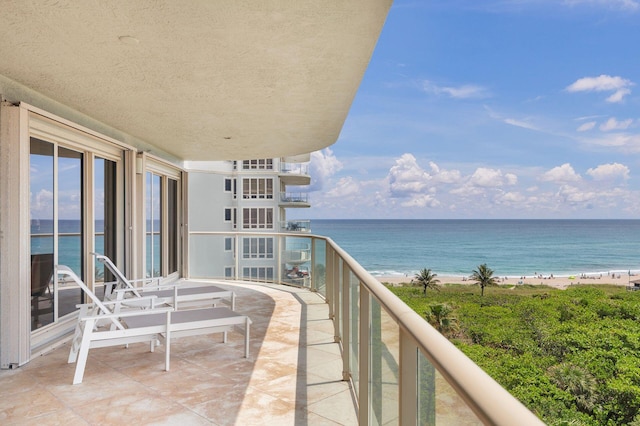 balcony with a water view and a beach view