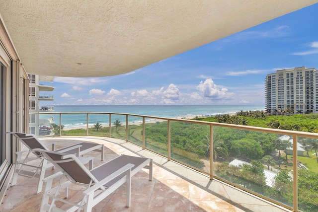 balcony featuring a water view and a view of the beach