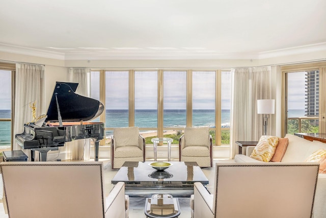 living room with a view of the beach, a water view, and ornamental molding