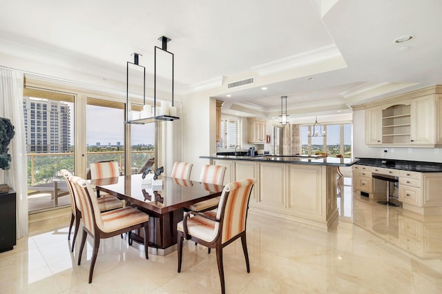 dining room with a tray ceiling, crown molding, and sink