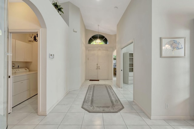 tiled foyer featuring high vaulted ceiling and independent washer and dryer