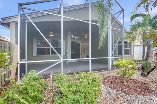 rear view of property with ceiling fan, a lanai, and a patio