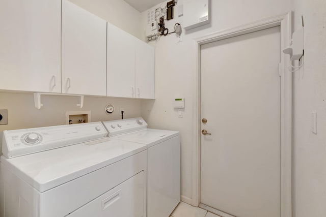 laundry room featuring cabinets, independent washer and dryer, and light tile patterned floors