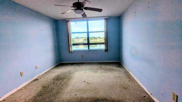 carpeted empty room featuring ceiling fan and a textured ceiling