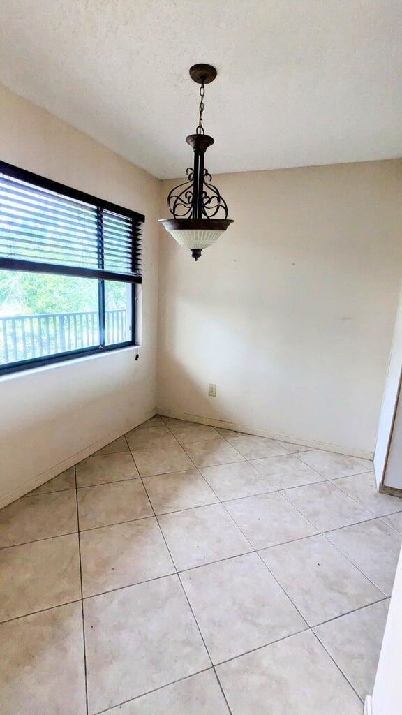 unfurnished dining area with light tile patterned floors and a textured ceiling