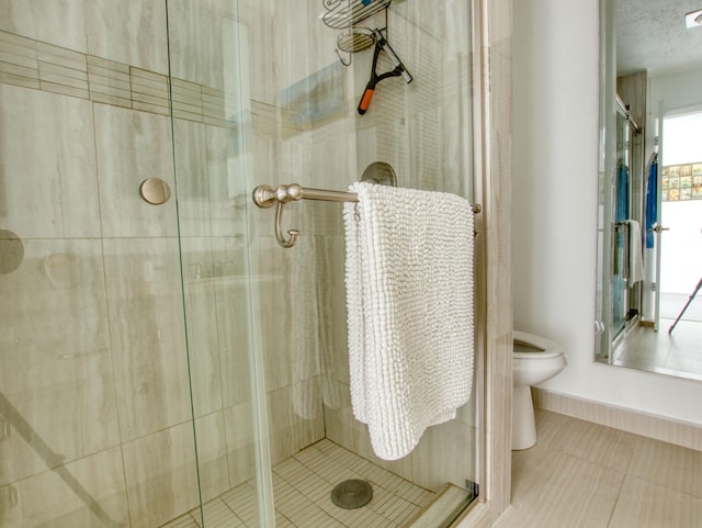 bathroom featuring tile floors, toilet, and walk in shower