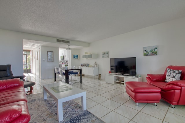 tiled living room featuring a textured ceiling