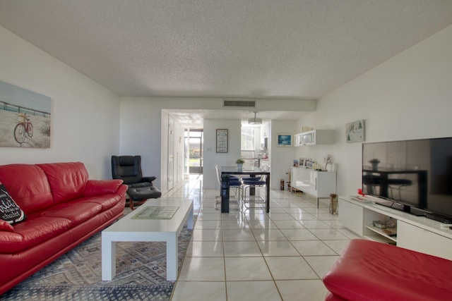 living room with a textured ceiling and light tile floors