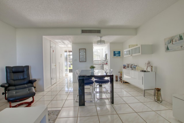 tiled dining space featuring a textured ceiling