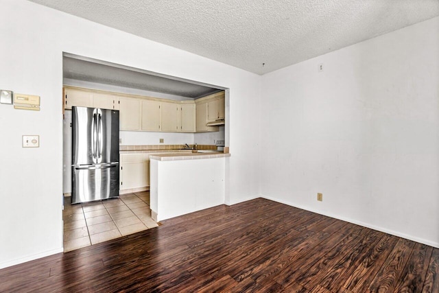 kitchen featuring stainless steel refrigerator, tile countertops, and light wood-type flooring